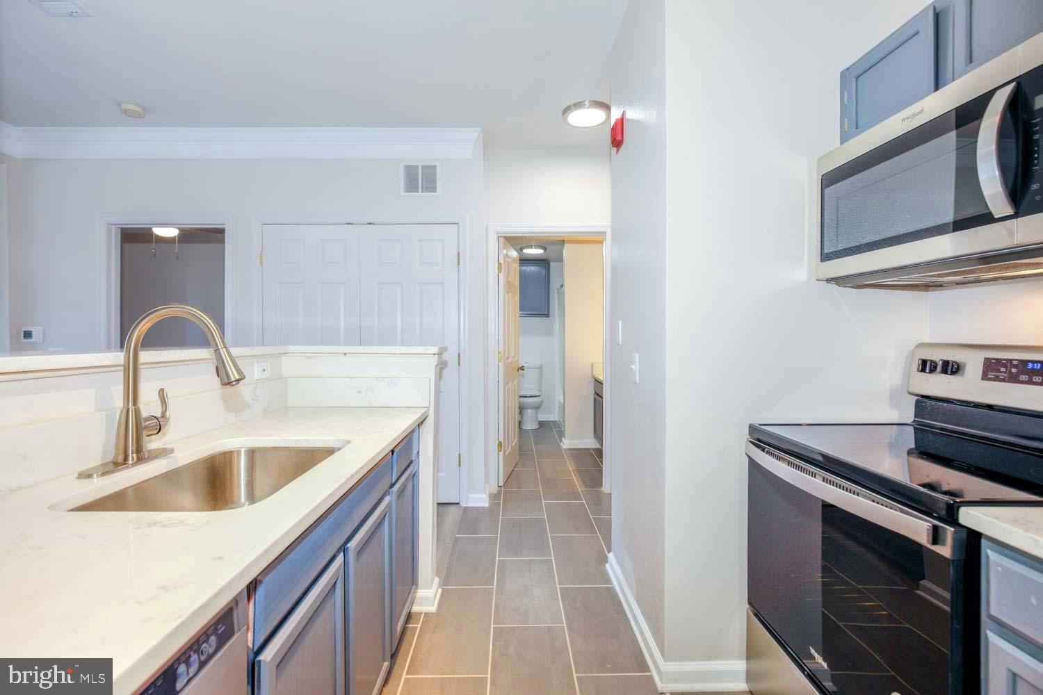 1530 Spring Gate Dr., Unit 9213 McLean, VA 22102 - Photo 10 of 24 a kitchen with a sink and a stove top oven with wooden floor