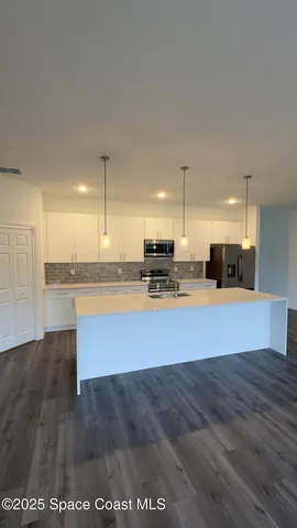 a view of kitchen with stainless steel appliances granite countertop a stove a sink and a refrigerator