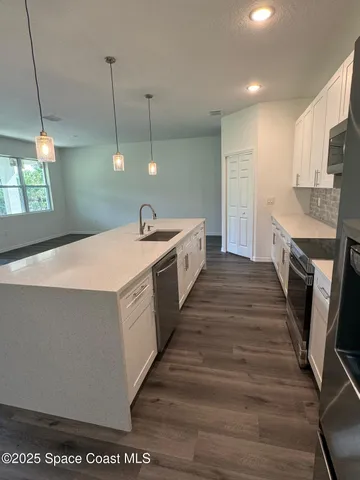 a large kitchen with sink a refrigerator and a stove