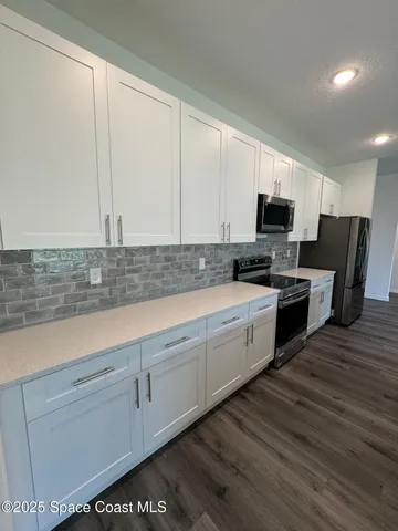 a kitchen with kitchen island granite countertop a sink counter top space and cabinets
