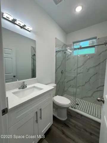 a bathroom with a sink toilet a mirror and shower