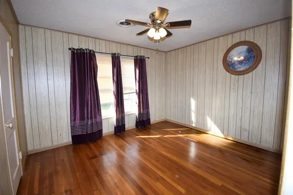 an empty room with wooden floor and a large window