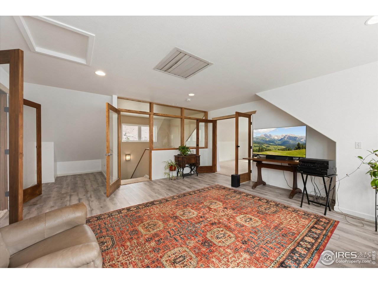 229 Rustic Road Bellvue, CO 80512 - Photo 33 of 50 a living room with furniture a dining table and large windows with wooden floor