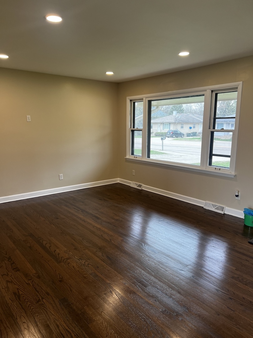 281 Chicago Road Oswego, IL 60543 - Photo 9 of 16 an empty room with wooden floor and windows