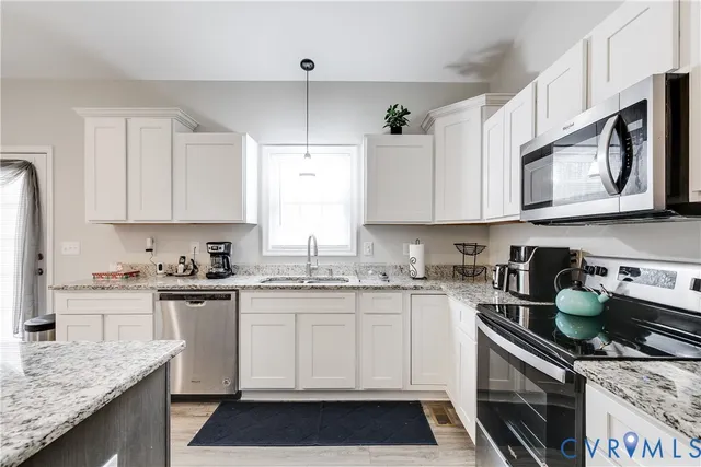 a kitchen with stainless steel appliances granite countertop a sink stove and cabinets