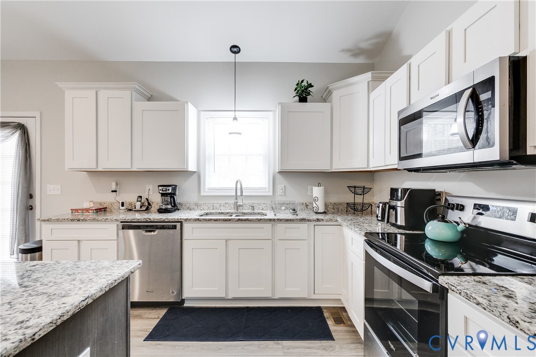10525 Amelia Springs Road Jetersville, VA 23083 - Photo 14 of 25 a kitchen with stainless steel appliances granite countertop a sink stove and cabinets