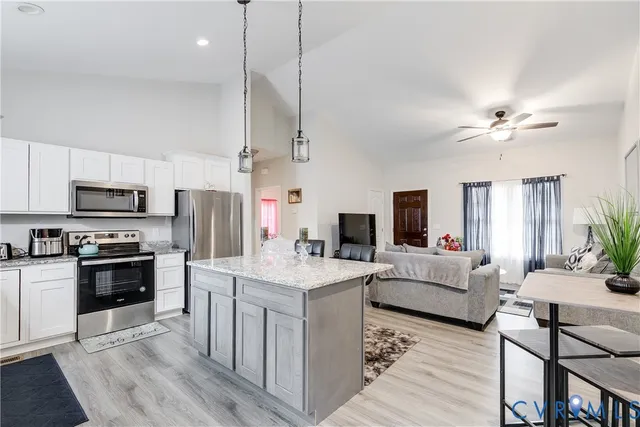 a kitchen with kitchen island white cabinets and stainless steel appliances