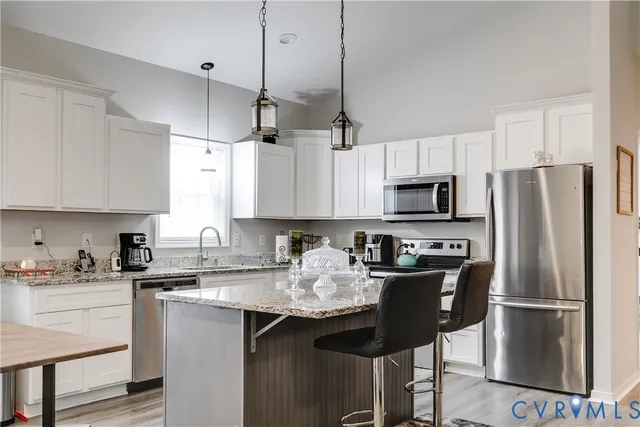 a kitchen with stainless steel appliances granite countertop a refrigerator a sink a stove a microwave and wooden cabinets