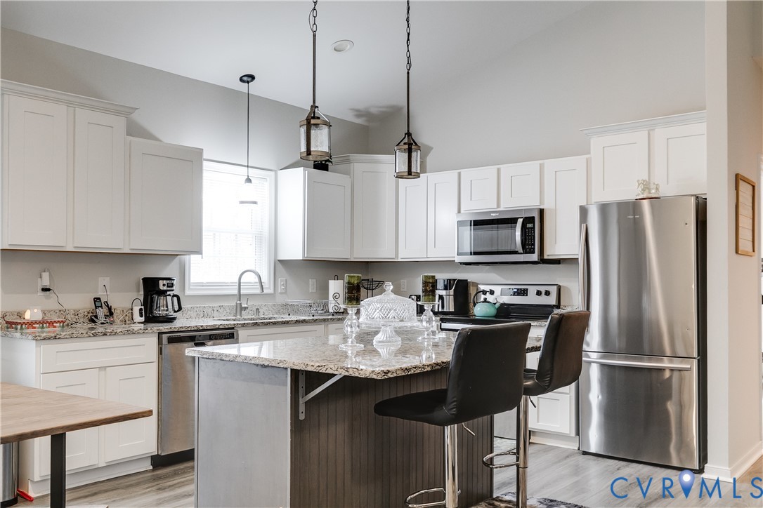 10525 Amelia Springs Road Jetersville, VA 23083 - Photo 18 of 25 a kitchen with stainless steel appliances granite countertop a refrigerator a sink a stove a microwave and wooden cabinets