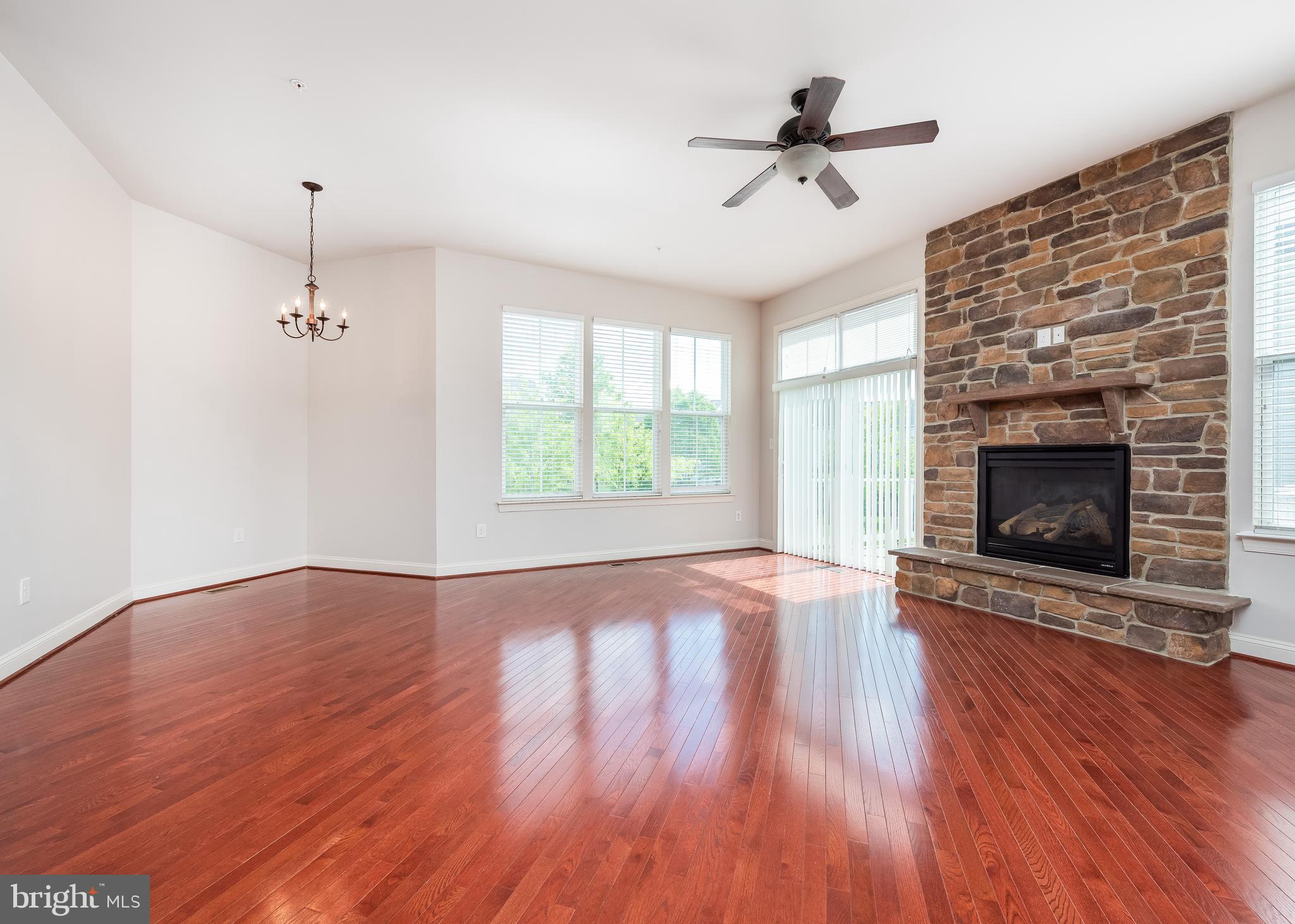 9830 Garden Ranges Laurel, MD 20723 - Photo 31 of 34 an empty room with windows fireplace and a kitchen view