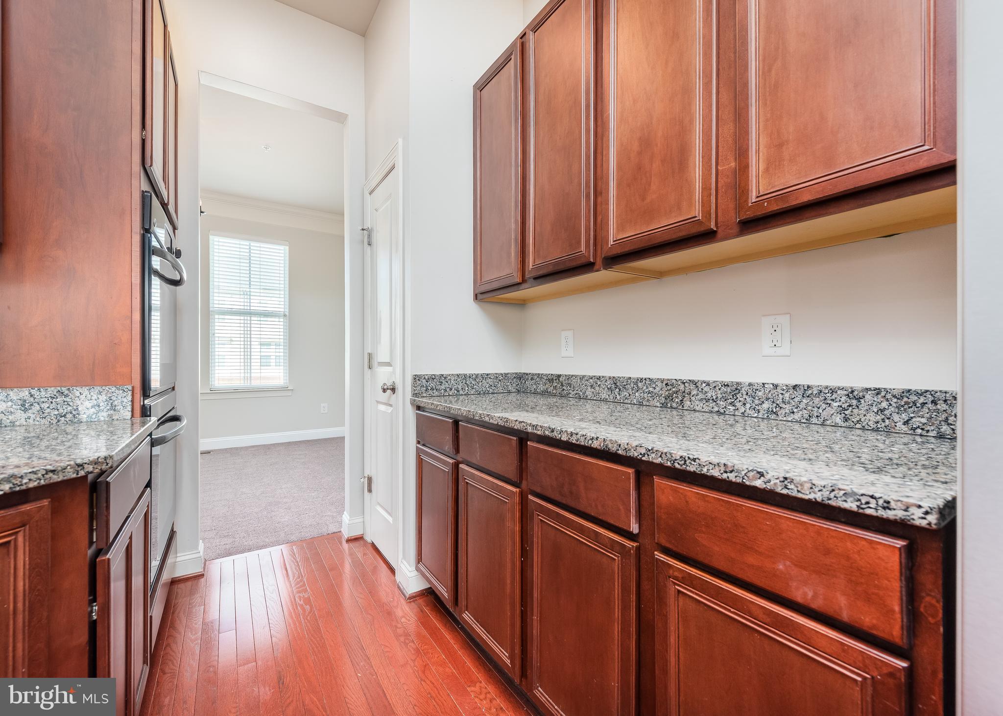 9830 Garden Ranges Laurel, MD 20723 - Photo 4 of 34 a kitchen with granite countertop wooden cabinets a sink and dishwasher