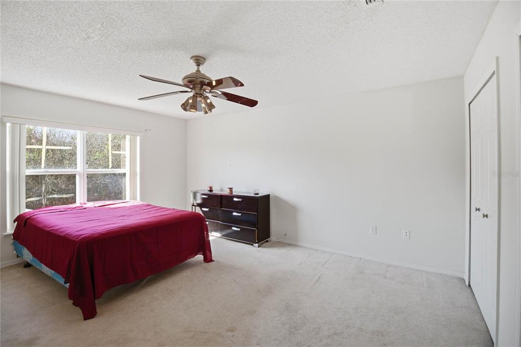 206 Taranto Way Kissimmee, FL 34758 - Photo 29 of 45 a bedroom with a bed and a chandelier fan