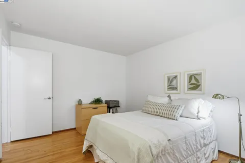 a bedroom with a bed and wooden floor