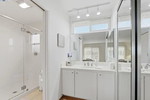 a bathroom with a shower sink and mirror