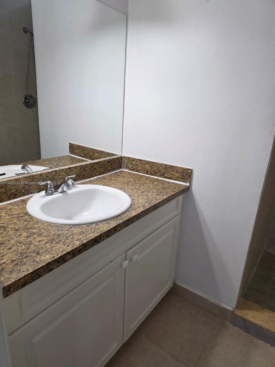 1206 Seaview, Unit 1206 North Lauderdale, FL 33068 - Photo 11 of 17 a bathroom with a granite countertop sink and a mirror