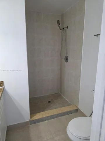 a bathroom with a granite countertop toilet and a shower