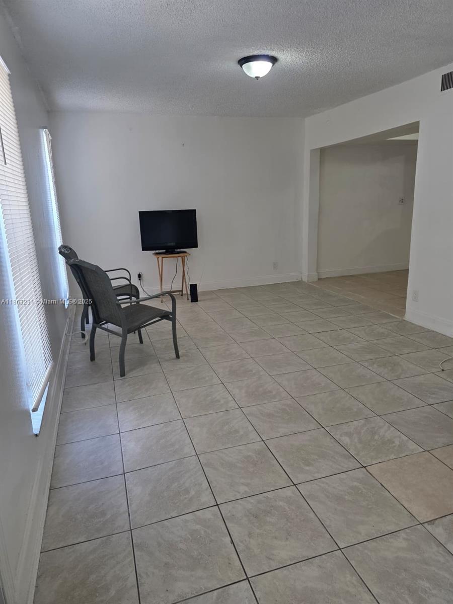 1206 Seaview, Unit 1206 North Lauderdale, FL 33068 - Photo 3 of 17 a living room with furniture and a flat screen tv