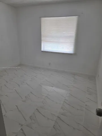 a view of a small space with wooden floor and a window