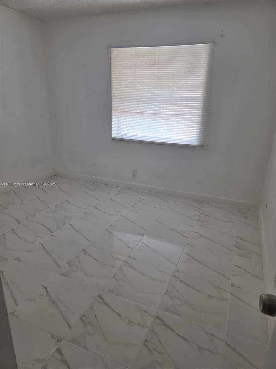 1206 Seaview, Unit 1206 North Lauderdale, FL 33068 - Photo 9 of 17 a view of a small space with wooden floor and a window