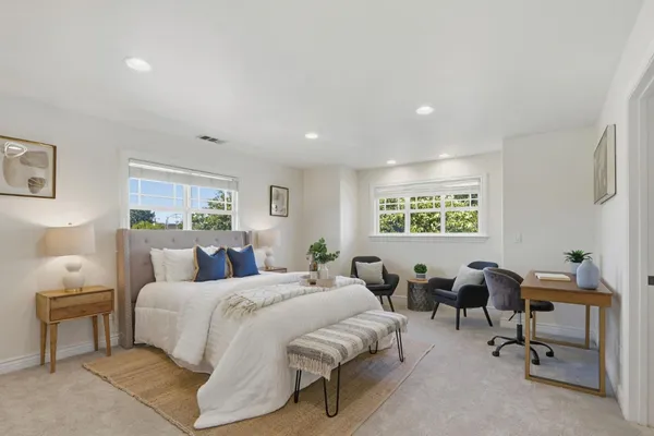 a bedroom with a bed a table and a window