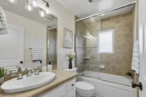 a bathroom with a granite countertop sink toilet and shower