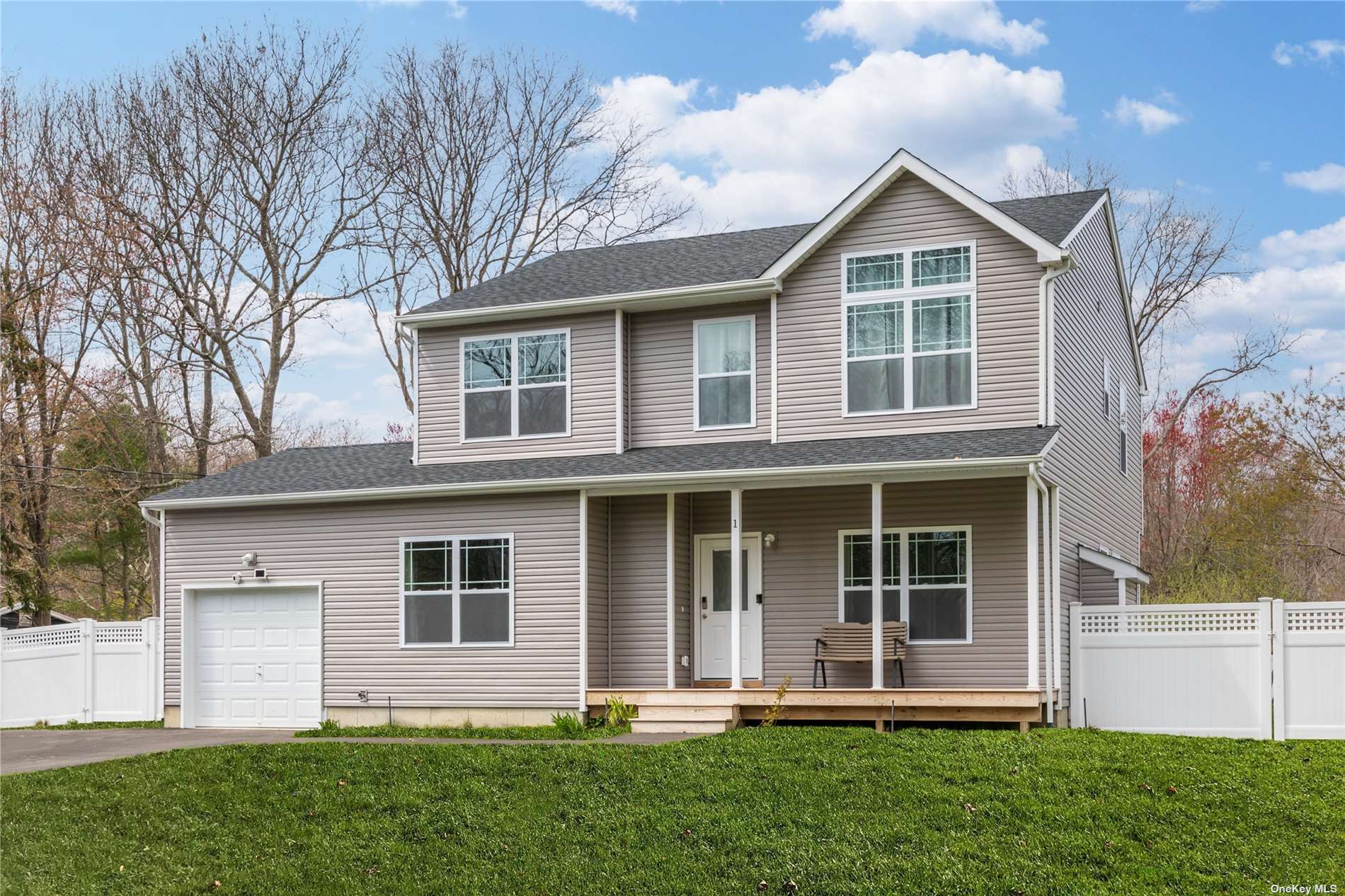 a front view of a house with a yard and trees