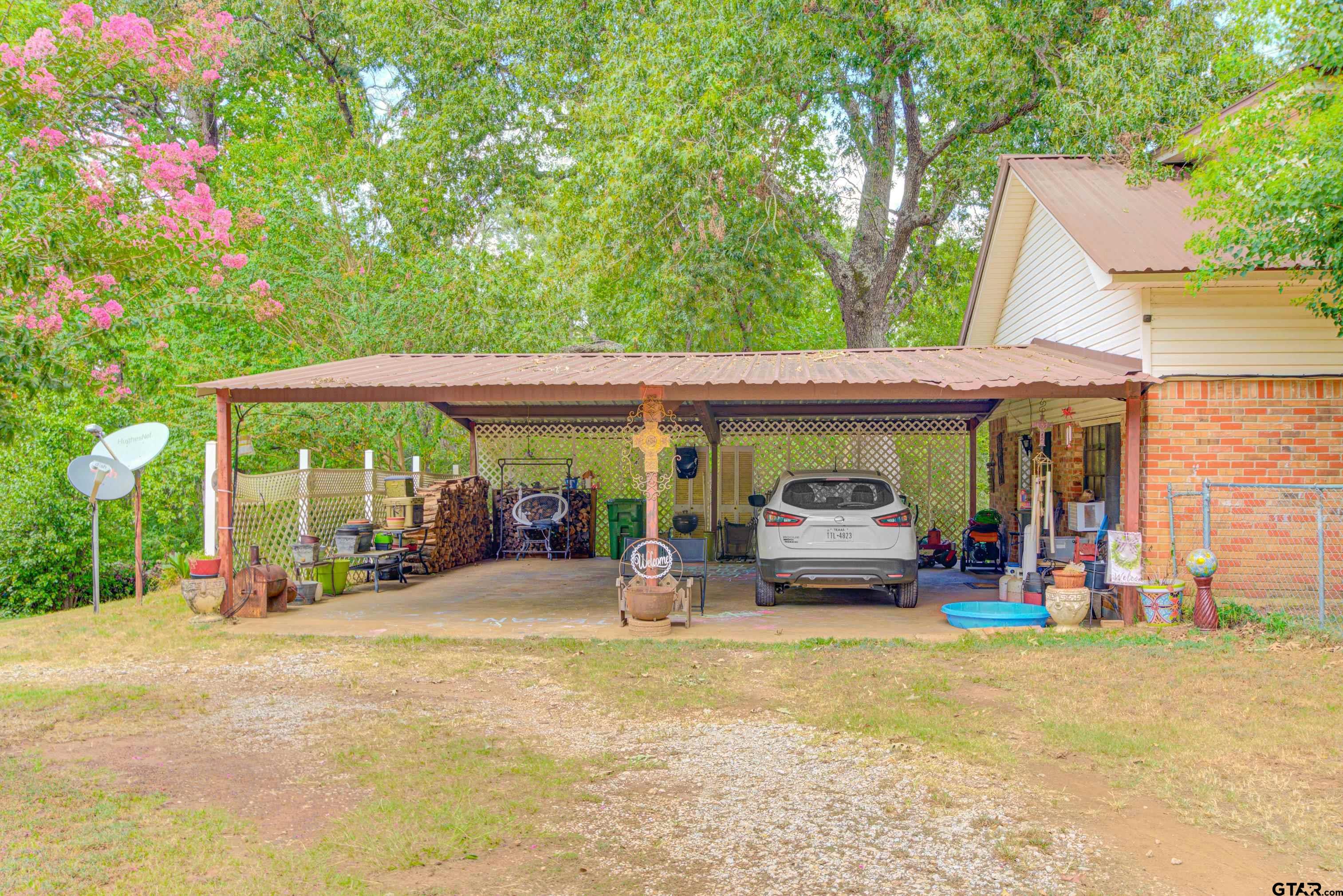 9315 Farm To Market Road 851 Rusk, TX 75785 - Photo 4 of 34 a view of a house with large windows and a table and chairs under an umbrella