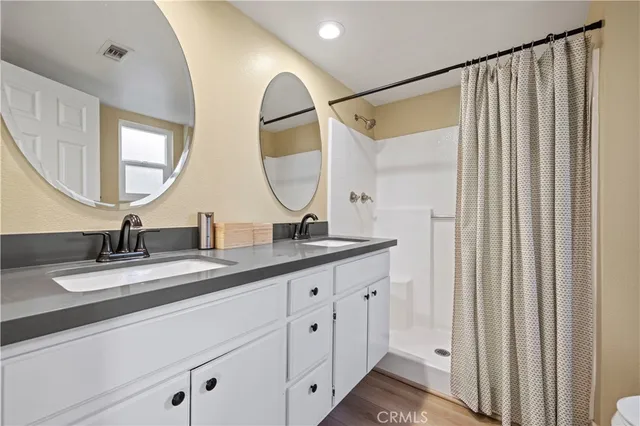 a bathroom with a double vanity sink and a mirror