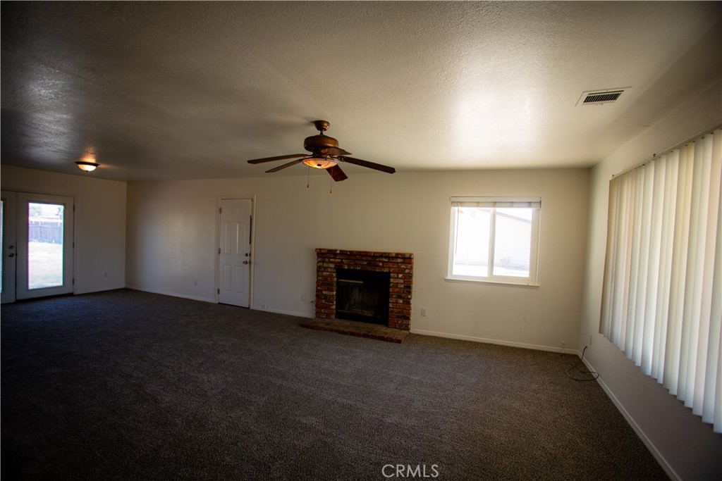 21090 Lone Eagle Road Apple Valley, CA 92308 - Photo 2 of 11 an empty room with windows and fireplace