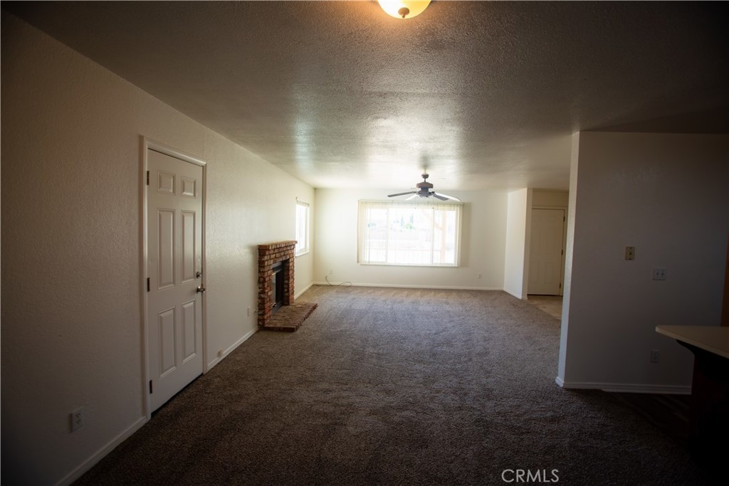 21090 Lone Eagle Road Apple Valley, CA 92308 - Photo 4 of 11 an empty room with windows and fireplace