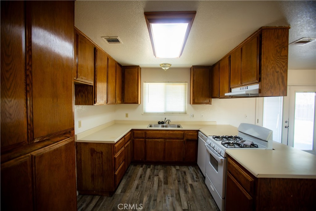 21090 Lone Eagle Road Apple Valley, CA 92308 - Photo 5 of 11 a kitchen with granite countertop stainless steel appliances a sink stove top oven and cabinets