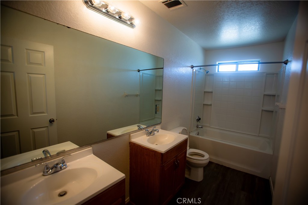 21090 Lone Eagle Road Apple Valley, CA 92308 - Photo 8 of 11 a bathroom with a toilet sink and mirror