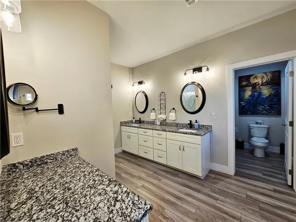 a spacious bedroom with a bed and wooden floor