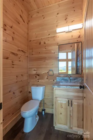 a bathroom with a granite countertop toilet and a sink