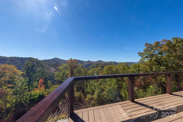 a view of a balcony with wooden floor and a floor to ceiling window