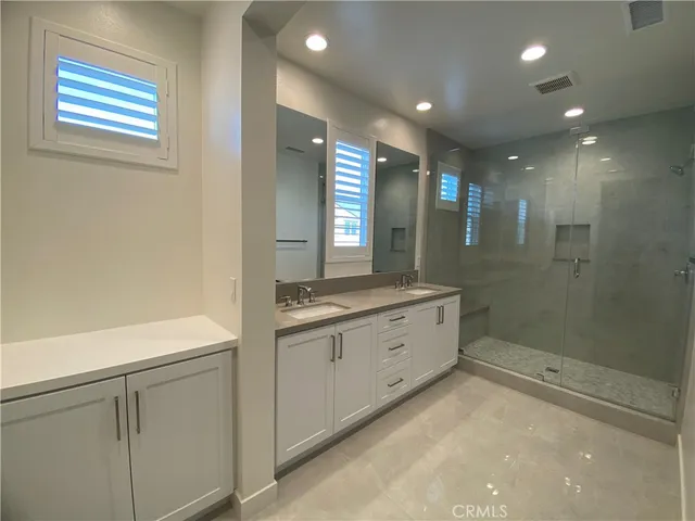 a bathroom with a double vanity sink toilet and shower
