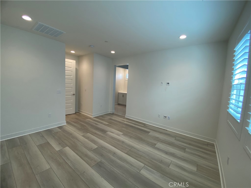 602 Jasper Street Rancho Mission Viejo, CA 92694 - Photo 13 of 18 an empty room with wooden floor and windows