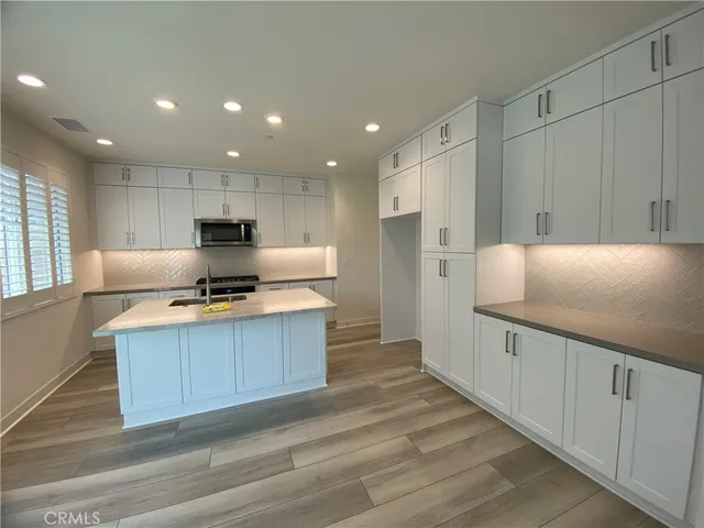 a kitchen with stainless steel appliances a refrigerator sink and cabinets