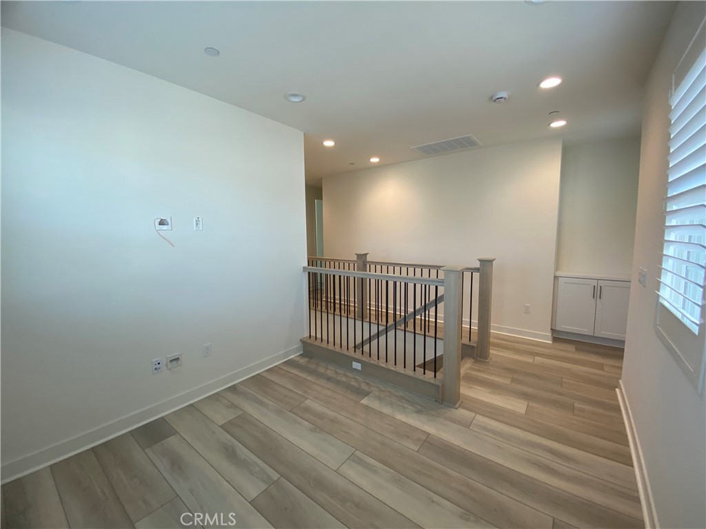 602 Jasper Street Rancho Mission Viejo, CA 92694 - Photo 10 of 18 an empty room with wooden floor and windows