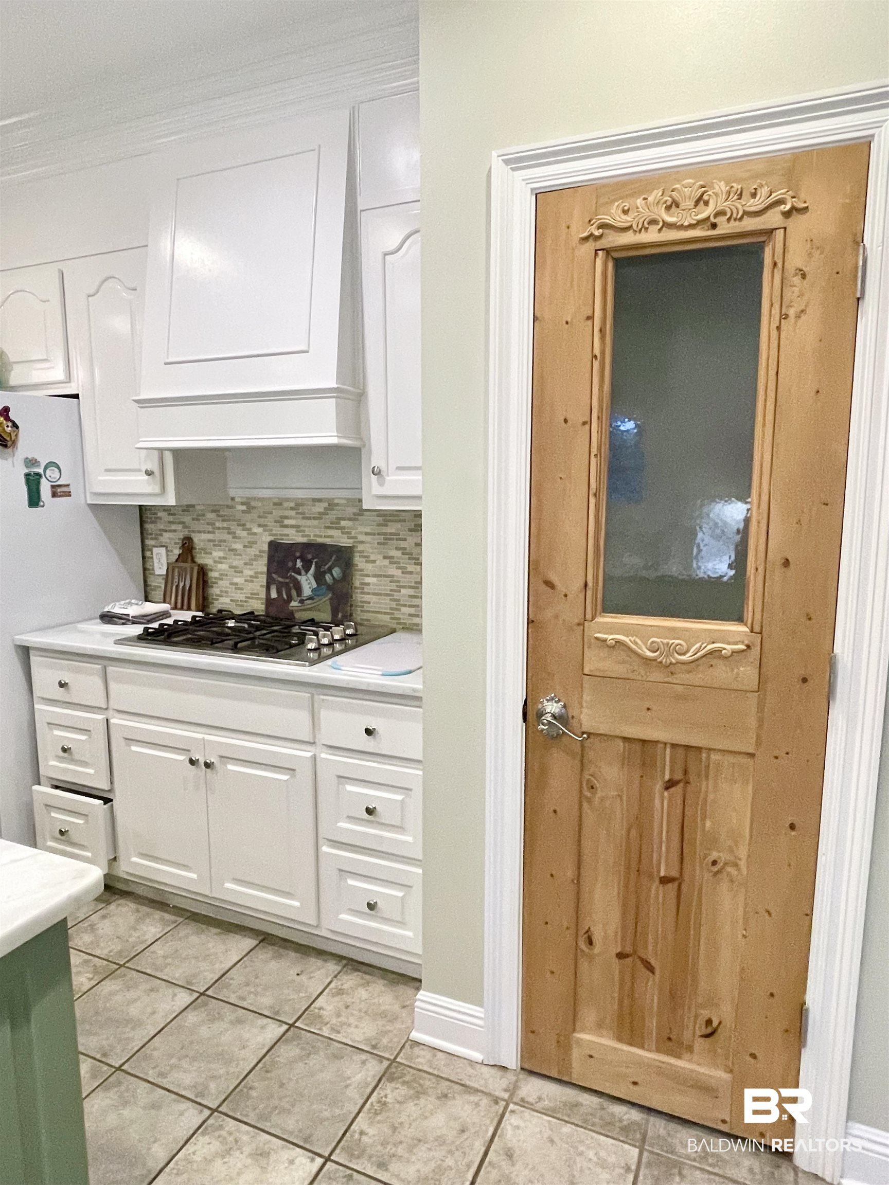 202 Potters Mills Road Daphne, AL 36526 - Photo 13 of 29 Kitchen featuring white cabinetry, premium range hood, light tile patterned flooring, decorative backsplash, and stainless steel gas cooktop