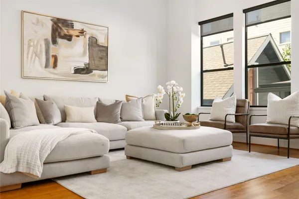 a living room with furniture large window and a wooden floor