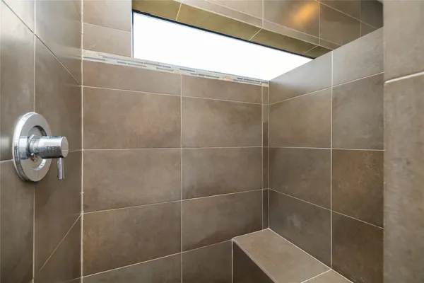 a bathroom with a granite countertop sink and mirror with bathtub