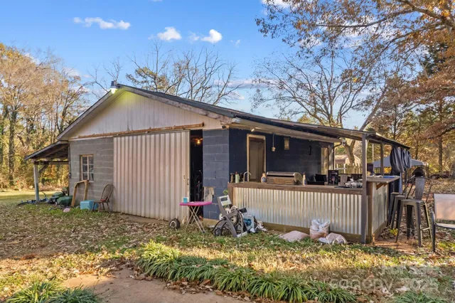 a view of a house with a yard and large tree