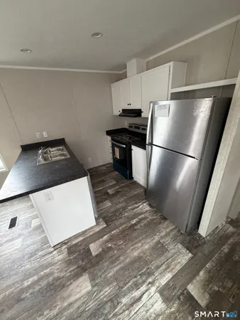 a kitchen with a refrigerator and a stove top oven