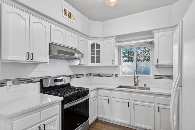 a kitchen with stainless steel appliances granite countertop a sink stove and cabinets