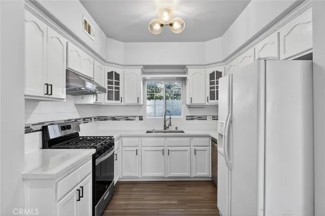 a kitchen with stainless steel appliances a sink stove and refrigerator