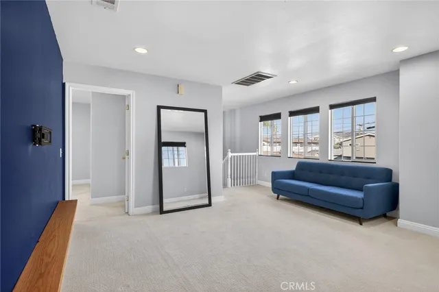a view of an empty room with wooden floor and windows