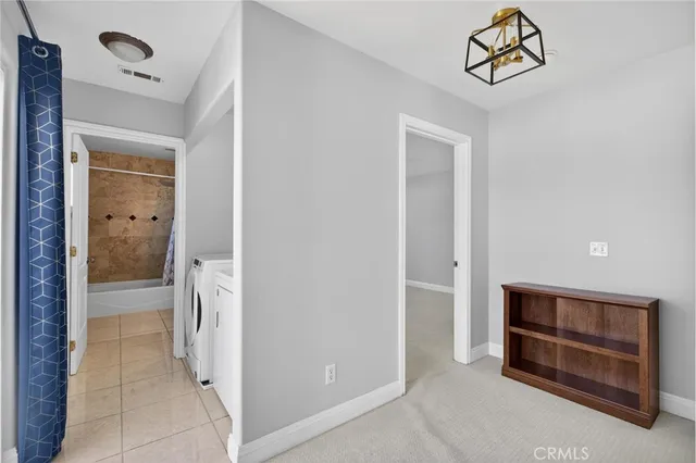 a view of washer and dryer with kitchen in the background
