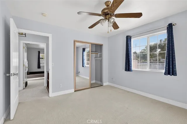 an empty room with windows and ceiling fan