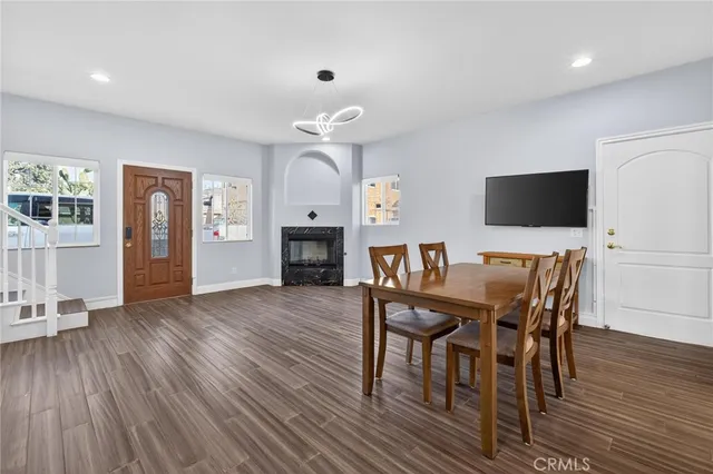 a view of a dining room with furniture wooden floor and a flat screen tv